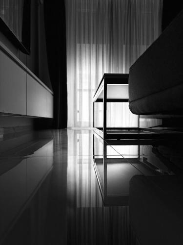 a living room with a chair and a glass table at Royal Apartments in Skopje