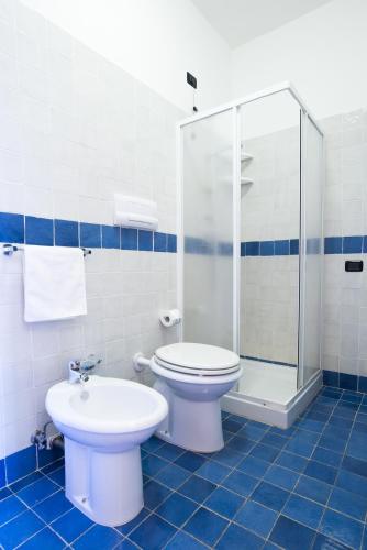 a blue and white bathroom with a toilet and a shower at Il Poggio del Mare in San Mauro Cilento