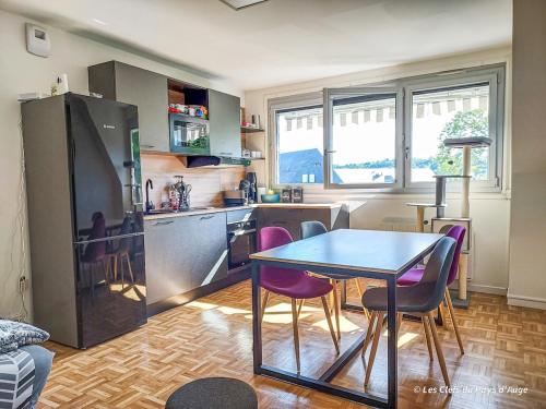 - une cuisine avec une table et des chaises violettes dans la chambre dans l'établissement Bel appartement, 2 chambres, proche gare et centre ville, tout à pied, à Lisieux