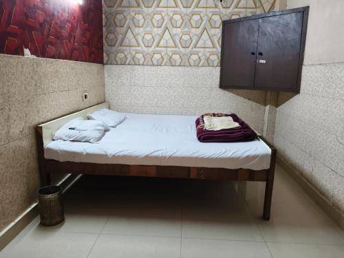 a small bed in a room with a cabinet at The Shivam Inn in New Delhi