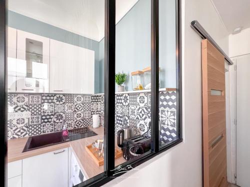 - une cuisine avec du carrelage noir et blanc sur le mur dans l'établissement Studio vue sur les Halles de Toulon 2 Couchages, à Toulon
