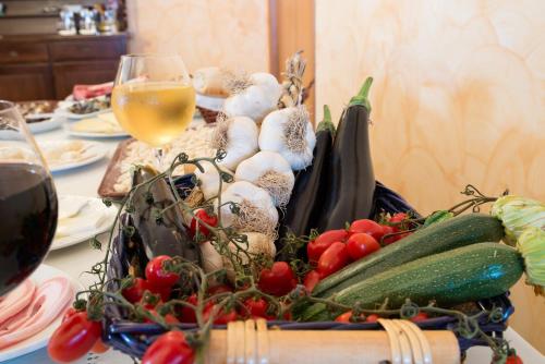 a table with a bunch of vegetables and a glass of wine at Il Poggio del Mare in San Mauro Cilento