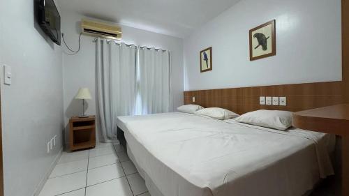 ein Schlafzimmer mit großem Bett und Fernseher in der Unterkunft Apartamentos Golden Dolphin Grand Hotel in Caldas Novas