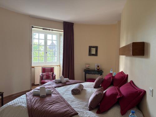 a bedroom with a large bed with red pillows at Domaine familial du château de Ragny in Savigny-en-Terre-Plaine