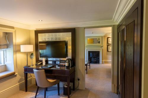 a hotel room with a desk and a television at Wood Hall Hotel & Spa in Wetherby