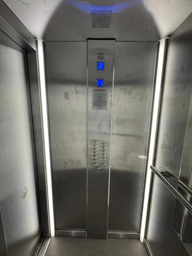 a metal elevator in a subway train with blue lights at Royal Apartments in Skopje