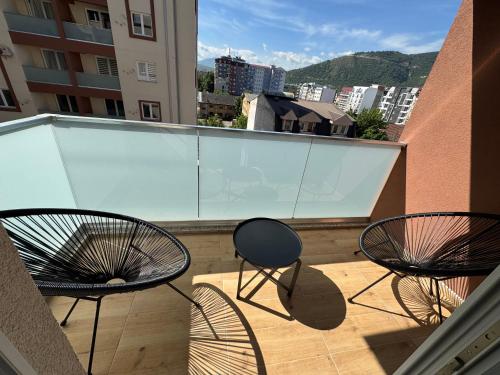 three chairs on a balcony with a view of a city at Royal Apartments in Skopje