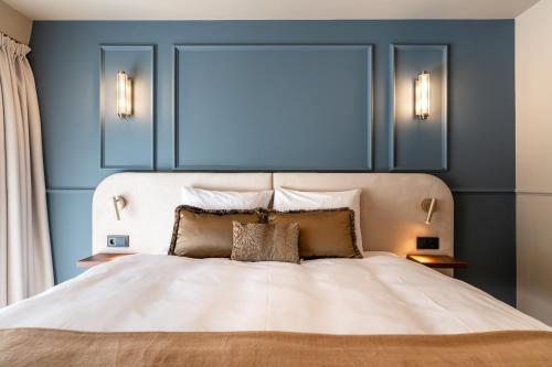 a bedroom with a white bed with blue walls at Malie House in Utrecht