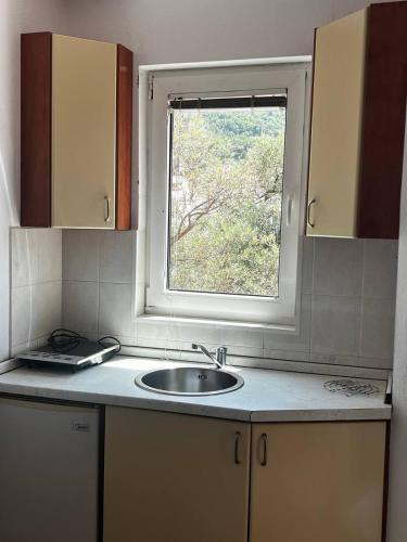 a kitchen with a sink and a window at Better place in Becici