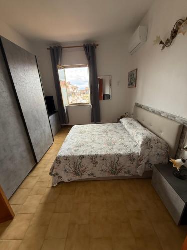 a bedroom with a large bed and a window at B&B Arcipelago in La Maddalena