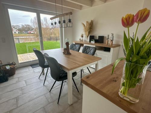 a kitchen with a table and chairs and a vase with flowers at Ferienhaus Emily in Nordhorn