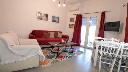 a living room with a red couch and chairs at Popi Studio 2, Mochos Square in Mokhós