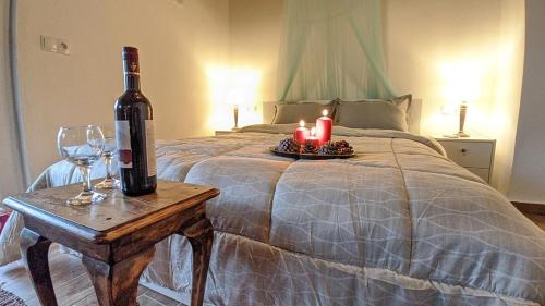 a bed with a bottle of wine and candles on a table at Popi Studio 2, Mochos Square in Mokhós