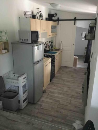 Il comprend une cuisine équipée d'un réfrigérateur et d'une cuisinière. four supérieur dans l'établissement Studio à 50M de la mer avec SPA, à Grandcamp-Maisy