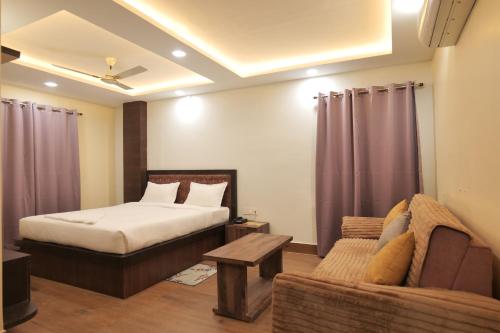 a bedroom with a bed and a couch at Hotel Devinn Begusarai in Begusarai