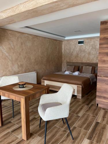 Un dormitorio con una cama, un escritorio y una mesa. en Zoranov Konak Vista, en Jevtići