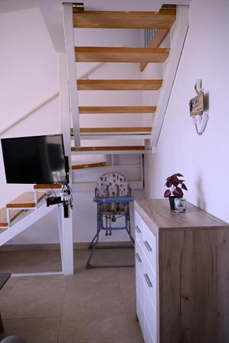 a living room with a tv and a staircase at Apartments Danica in Petrovac na Moru