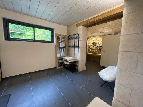 a room with a stone wall and a window at Chambre Saumur in Le Petit-Pressigny
