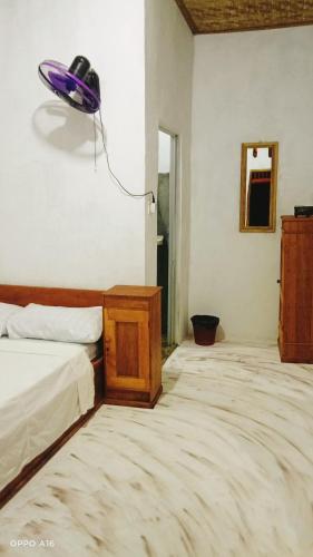 a bedroom with a bed and a lamp on the wall at Twins Homestay ekas in Pulau Gilkaliantan