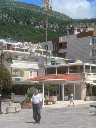 a man walking down a street in front of a building at Better place in Becici