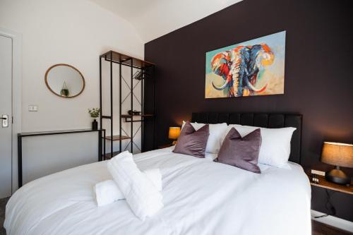 een slaapkamer met een groot wit bed met paarse kussens bij The Bishops Nest in Bishop Auckland