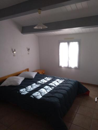 a bedroom with a large black bed with two windows at Maisonnette de vacances Noirmoutier quartier Epine in LʼÉpine