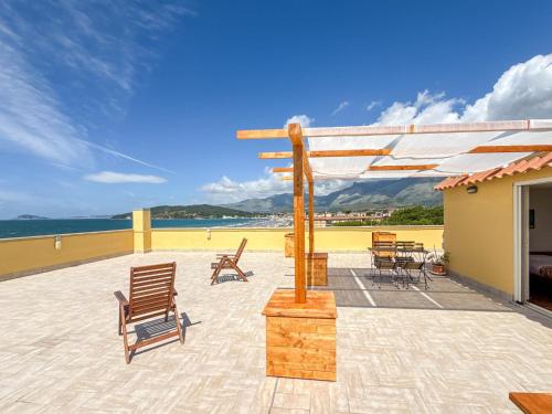 a patio with chairs and a wooden pergola at Il Mare In Giardino in Scauri