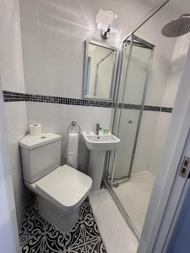 a bathroom with a toilet and a sink and a shower at Stanley House Hotel in London