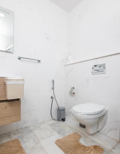 a white bathroom with a toilet and a sink at Otto By Atlantis in Agadir