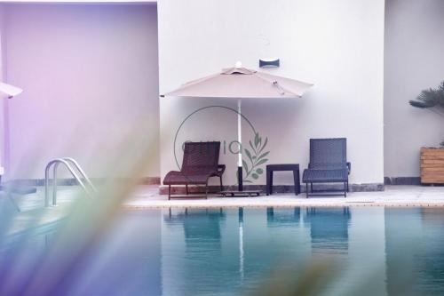 two chairs and an umbrella next to a swimming pool at Otto By Atlantis in Agadir