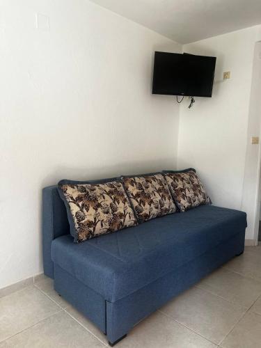 a blue couch sitting in a room with a flat screen tv at Better place in Becici