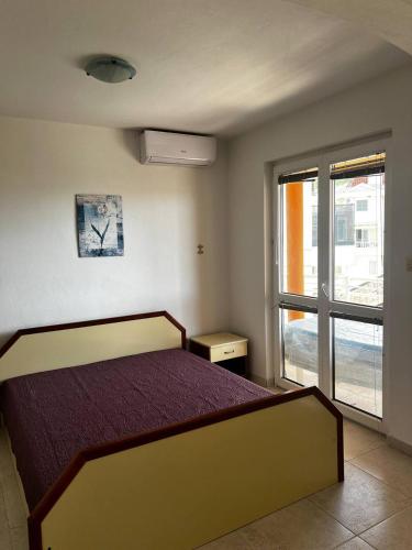 a bedroom with a bed and a large window at Better place in Becici
