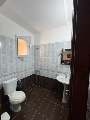 a bathroom with a toilet and a sink at Viron Apartament in Himare