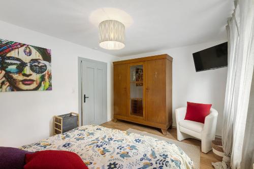 a bedroom with a bed and a chair and a television at Vogelsberger Bett unser Korkhaus in Köddingen