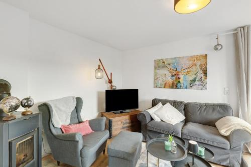 a living room with a couch and chairs and a tv at Vogelsberger Bett unser Korkhaus in Köddingen