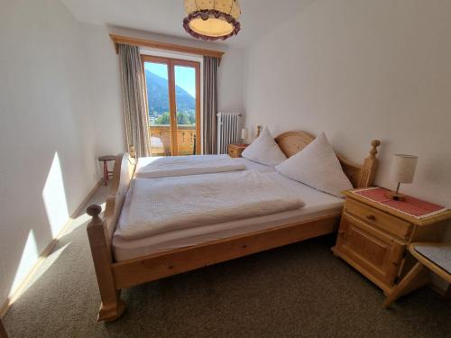 a bedroom with a large bed with a window at Brandnerhof in Berchtesgaden