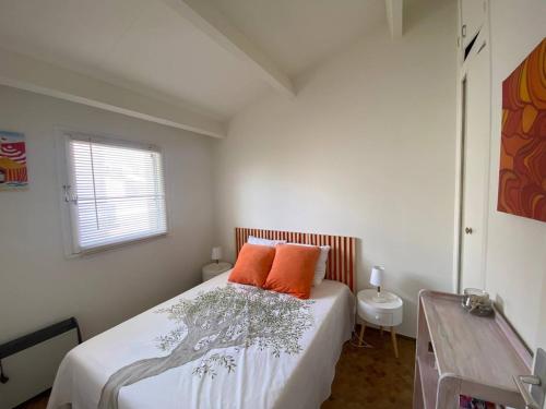 - une chambre dotée d'un lit avec deux oreillers orange dans l'établissement Appartement 2 Pièces, 4 Pers, Face Mer, Parking, Port-Leucate - FR-1-81-625, à Port-Leucate