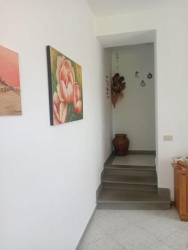 a hallway with stairs and paintings on the wall at ai Confini in Castelnuovo di Val di Cecina