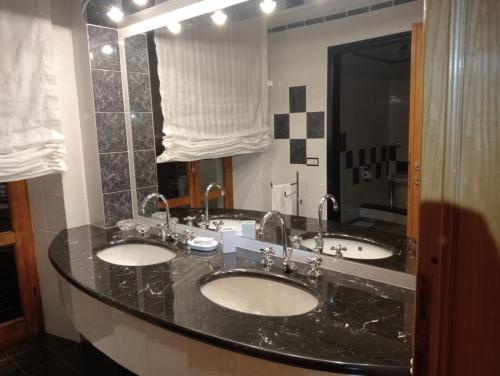 a bathroom with three sinks and a large mirror at ai Confini in Castelnuovo di Val di Cecina