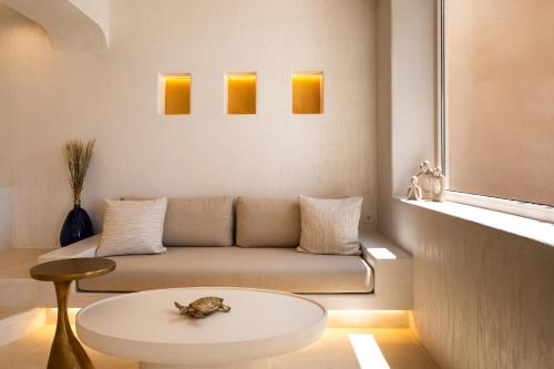 a living room with a couch and a table at Youtopia Ios Villas in Ios Chora