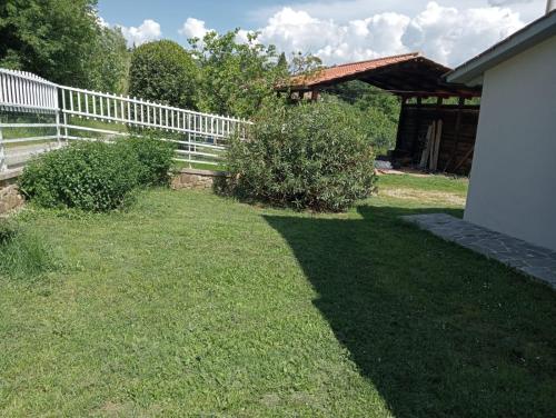 a yard with a white fence and green grass at ai Confini in Castelnuovo di Val di Cecina