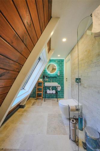 an attic bathroom with a tub and a sink at Grand Paradise Resort Sapanca in Sapanca