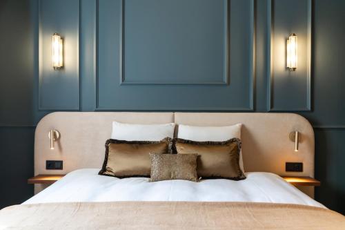 a bedroom with a bed with two pillows and blue walls at Malie House in Utrecht