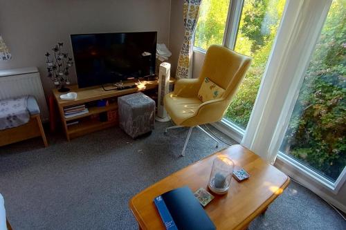 a living room with a television and a chair and a table at Sleeps 6 Pets Allowed & Free Parking in Weymouth