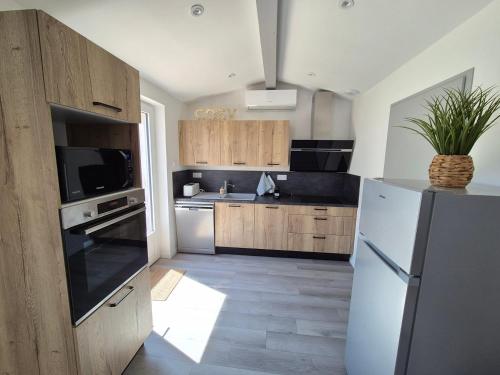 a kitchen with wooden cabinets and a stainless steel refrigerator at Appartement "Le Lotus" centre Cholet 6pers in Cholet