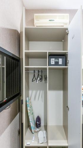 a walk in closet with a fan and a tv at Nizami Central Park Hotel in Baku