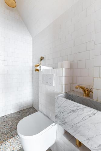 une salle de bain blanche avec des toilettes et un lavabo dans l'établissement Nicolo Passy Magnifique Studio, à Paris