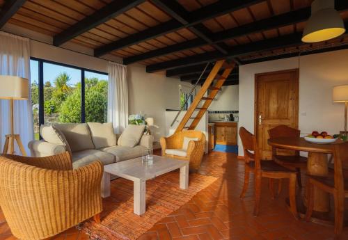 a living room with a couch and a table at Green OceanView Relaxing Cottage in Mosteiros