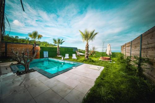 a swimming pool in a yard with palm trees at Grand Paradise Resort Sapanca in Sapanca
