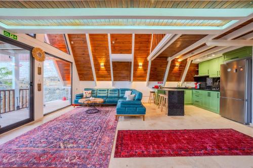 a living room with a blue couch and a kitchen at Grand Paradise Resort Sapanca in Sapanca